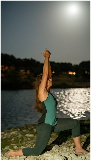 Portrait of Christina in a yoga pose under moonlight
