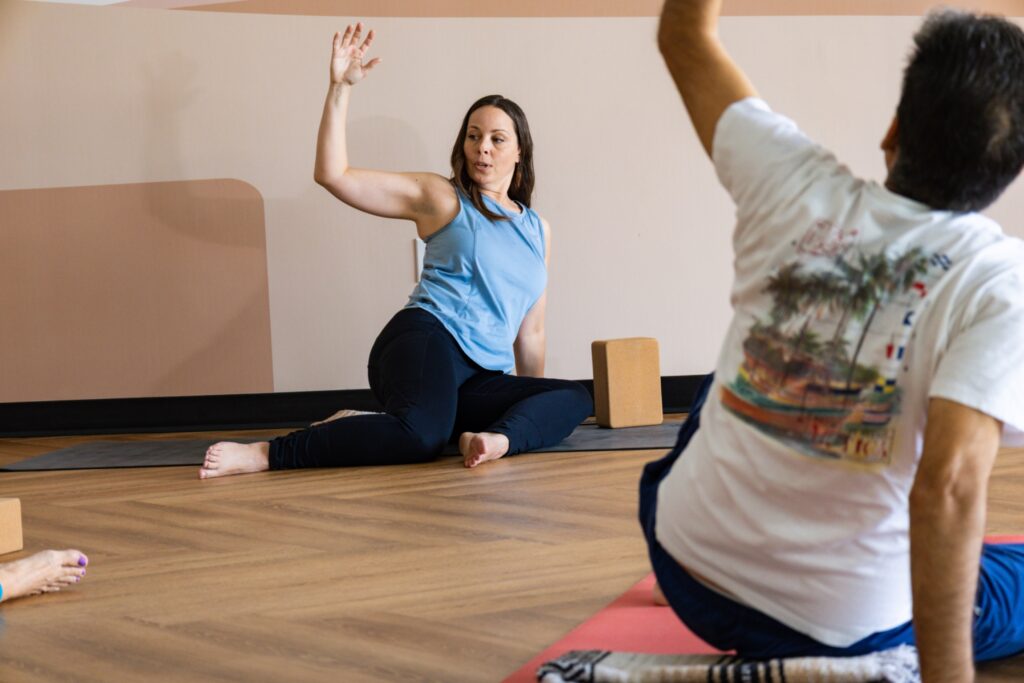 Christina guiding students in a seated twist