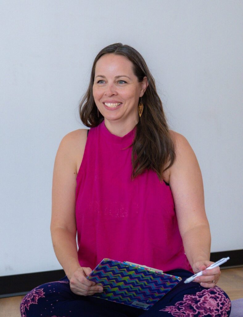 Christina smiling while holding a pen and clipboard