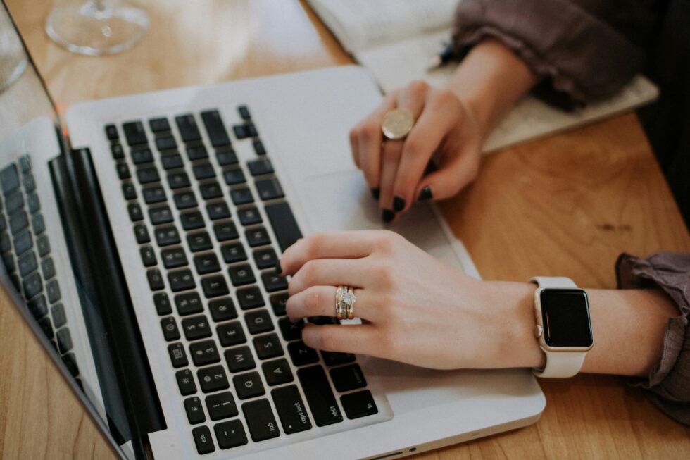 Woman's hands typing on a laptop