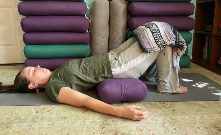 Christina lying in supported bridge pose