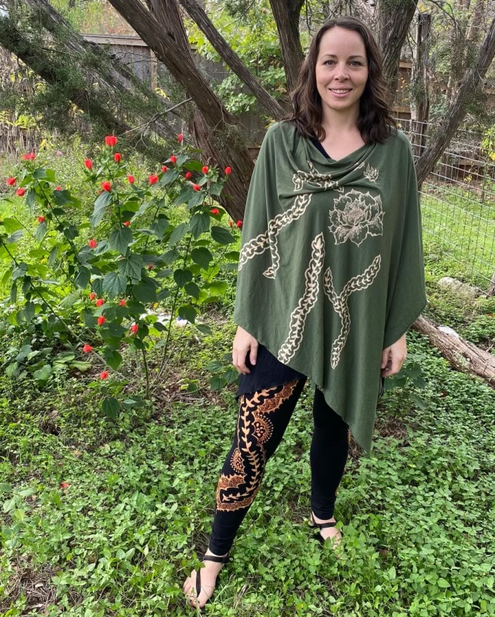 Christina standing in a lush backyard with turk's cap flowers